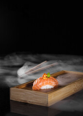 Salmon nigiri sushi with ikura and japanese chopsticks - obrazy, fototapety, plakaty