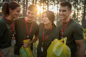 portrait of group of friends volunteers prepare to collect garbage waste and clean forest nature in...