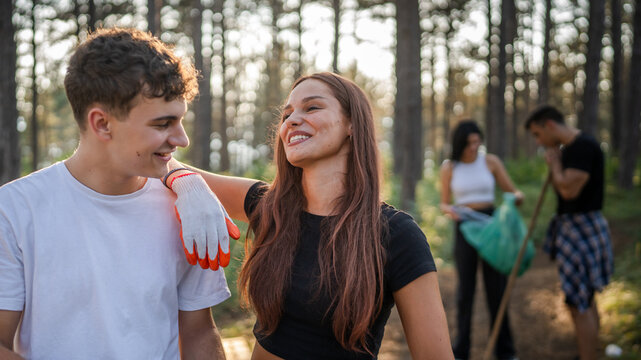 portrait couple in front of group of friends volunteers prepare to collect garbage waste and clean forest nature in summer day slow motion