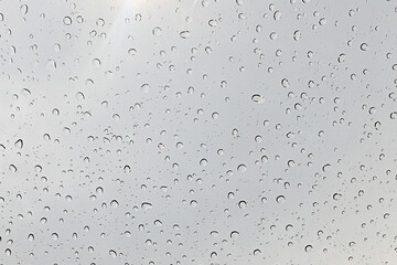 Drops of water on glass surface gray background, surface for creativity.	