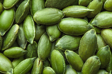 Pumpkin seeds, peeled kernels close-up, uniform texture background