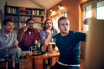 Young and diverse group of friends getting nervous during an intense soccer or football match on tv