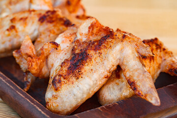 Barbecue chicken wings fried on wooden board close-up  selective focus .