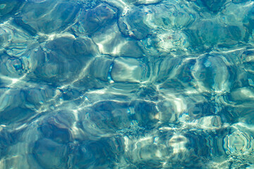 Clear sea water with excitement on surface, close-up, top view, transparent