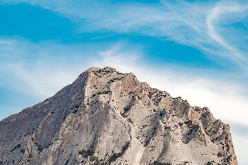 Top of stone mountain in close-up on clear day against blue sky, stones teeth