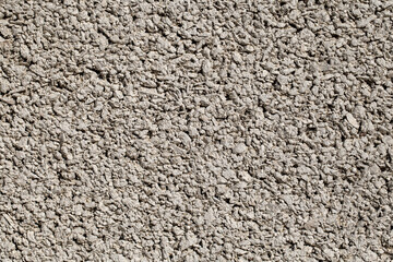 Background small fractions of crushed stone with sand frozen in cement mortar, close-up, uniform texture