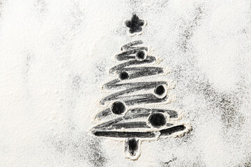 winter holidays and cooking concept - close up of christmas tree drawing on powdered sugar or flour on black background