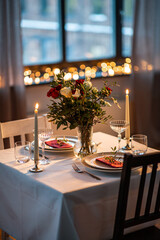 holidays, romantic date and celebration concept - close up of festive table serving for two with flowers in vase and candles burning at home on valentine's day - 645762834