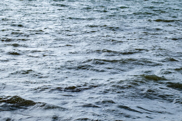 Water surface of the sea with slight waves in cloudy weather close-up