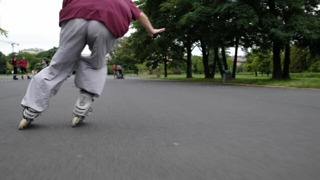 Girl practicing roller scating in park riding outdoor with speed. Ptrtty teenager enjoying active summer leisure