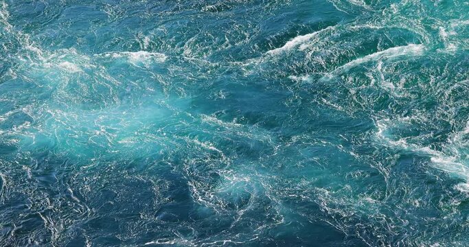 Blue waves of water of the river and the sea meet each other during high tide and low tide.