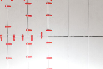 Flat wall plastic tile leveling system. Process of installation of tiles in the bathroom step by...