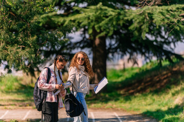 Two high school girls enjoying a walking in the park. They are having a conversation