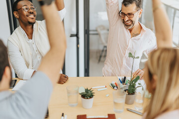 Multiracial, different aged business team celebrating new success and profit growth at the office.