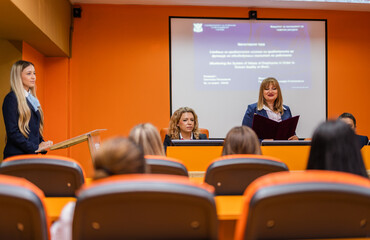 Student giving a speech to her professors and classmates