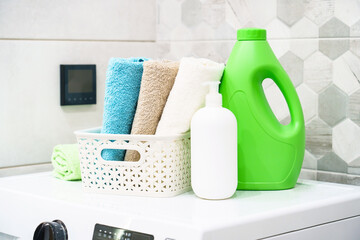 Clean towels and detergent at the washing machine in the laundry or bathroom.