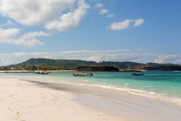 The most beautiful beach in Lombok and the closest to Kuta is Tanjung Aan Beach, A Hidden Gem Waiting for You to Explore on Lombok. beautiful beach surrounded by hills and blue sea