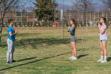 Friends exercising in park on a sunny day