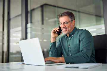 Busy smiling older middle aged business man professional expert or entrepreneur making phone call...