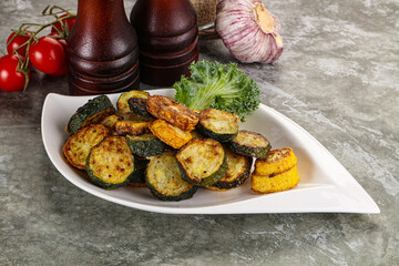 Roasted young zucchini in the plate