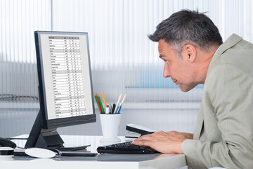 Fototapeta na wymiar Concentrated Businessman Using Computer At Desk