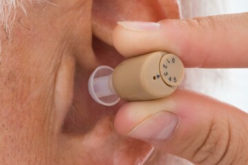 Fototapeta premium Doctor Putting Hearing Aid In Patient's Ear