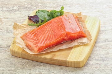 Raw salmon fillet over board