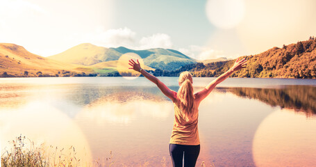 Lonely woman enjoying beautiful lake at sunset- freedom, adventure,healthy lifestyle