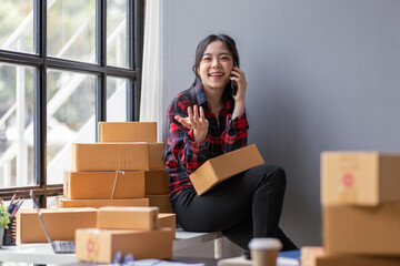 Startup happy Asian woman sme business owner work with prepare parcel delivery boxs at home, SME supply chain, procurement, package box to deliver to customers, Online SME business entrepreneurs ideas