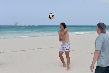 Male beach volleyball player passing the ball