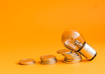 A lamp and money on a orange
 background with copy space. Price for electricity concept. Expensive...
