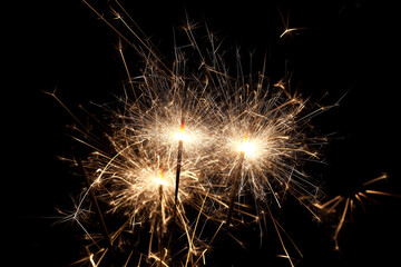 Burning sparklers on black background