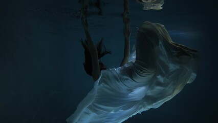 Slow motion plunging girl to fall under water. Girl swimming under water in basin. Woman dives in the pool. - Powered by Adobe