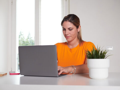 smiling woman working at home with laptop
