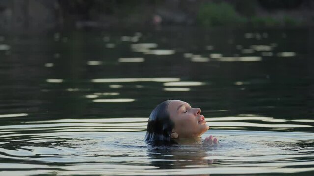 Girl emerges from the water. Hot girl in the water. Girl in wet clothes