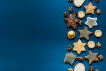 Hanukkah composition on blue background with menorah candles, dreidels, gelt coins and star of David cookies. Jewish festival of lights theme. Restangular Hanukkah background