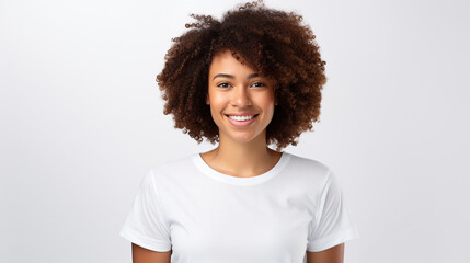 Young woman wearing white short sleeve top, a teenage, African girl smiling and standing against white background, studio shot.