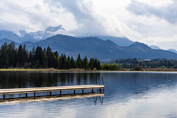 Tranquil landscape featuring an empty dock at a mountain lake in Bavarian Alps, Germany.