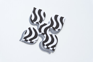 pile of spade-like quadrilateral machine-cut paper design or shapes with wavy lines on blank paper
