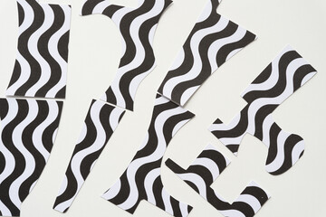Fototapeta na wymiar abstract machine-cut paper shapes cut from crafting paper with wavy black and white lines