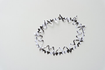 two machine-cut paper starburst shapes in black and white on blank paper