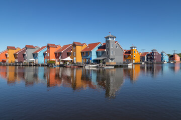 Fototapeta na wymiar Colorful promenade and pier houses at the Reitdiephaven in Groningen.