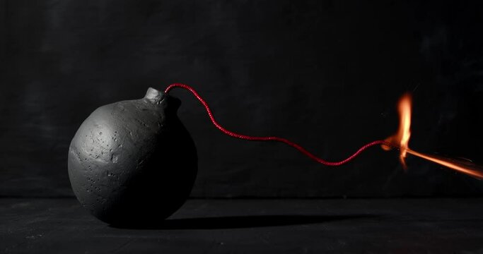 Round black bomb with lit fuse burning, sparking, and smoking. Bomb about to detonate symbolizing destruction, threats, or dangerous violence.