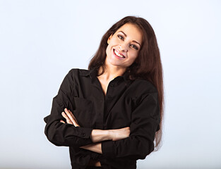 Happy toothy enjoying smiling brunette woman posing in blank black shirt and skirt standing with folded arms on blue background with empty copy space. Closeup front classic