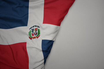 big waving national colorful flag of dominican republic on the gray background.