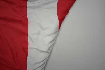 big waving national colorful flag of peru on the gray background.