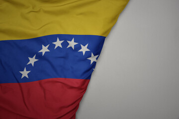 big waving national colorful flag of venezuela on the gray background.