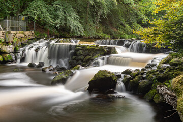Long exposure of the river Teign flowing through Castle Drogo weir in Dartmoor - obrazy, fototapety, plakaty