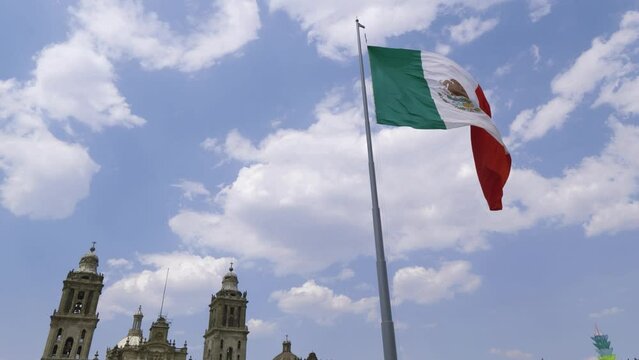 Mexican flag waving with blue sky and clouds and the Metropolitan Cathedral in the background, Zocalo, Mexico City  - Flag Waving, Mexico Flag