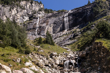 Mountain alpine landscape with rocks, waterfalls and clear sky, background, Austria